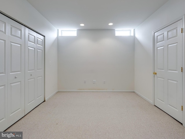 basement featuring a wealth of natural light and light carpet