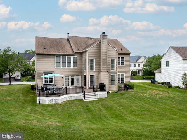 rear view of house with a yard, a deck, and central air condition unit