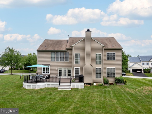 rear view of house with a wooden deck and a lawn