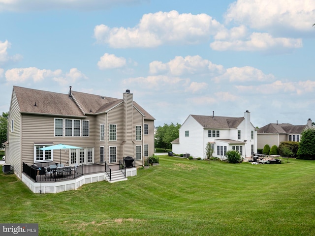 back of property with a lawn and a deck