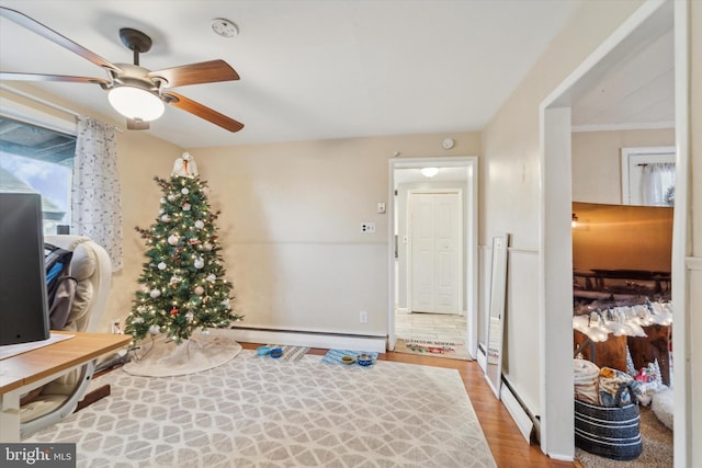 foyer featuring hardwood / wood-style floors, baseboard heating, and ceiling fan