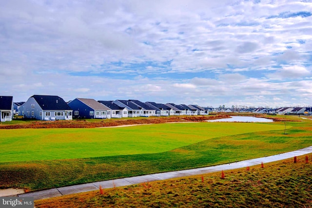 view of community with a lawn and a water view