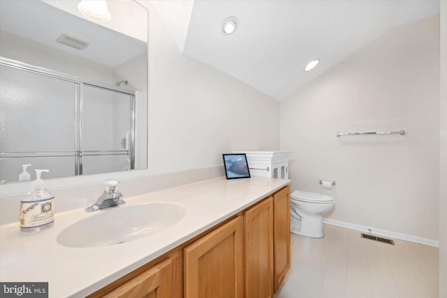 bathroom with toilet, vanity, a shower with shower door, and vaulted ceiling