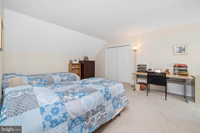 carpeted bedroom with a closet and vaulted ceiling