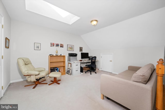 carpeted office space featuring vaulted ceiling with skylight