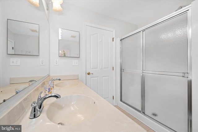 bathroom featuring a shower with door, tile patterned flooring, and vanity