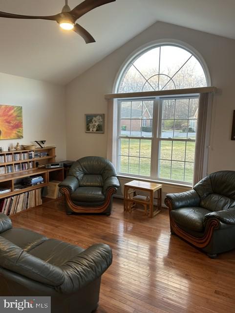 living room with vaulted ceiling, light wood-type flooring, and ceiling fan