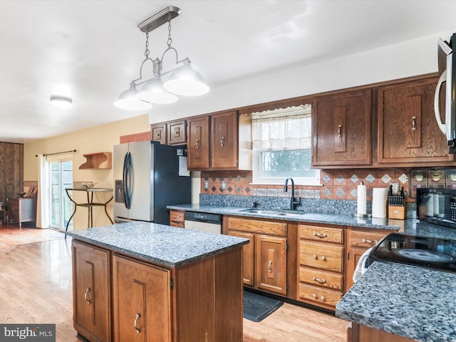 kitchen with pendant lighting, a center island, sink, tasteful backsplash, and stainless steel appliances