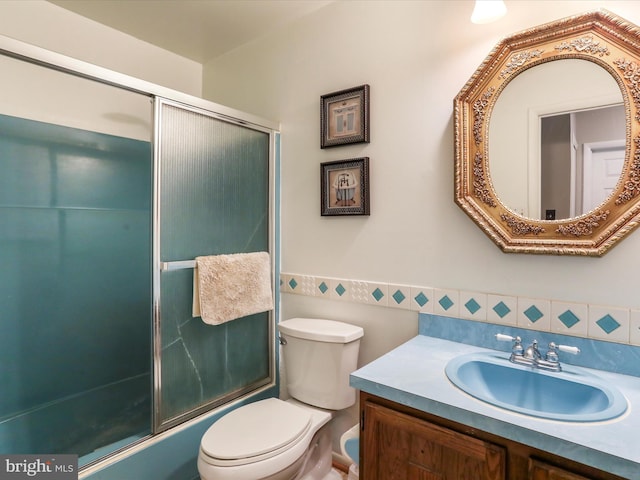 full bathroom with vanity, toilet, and enclosed tub / shower combo