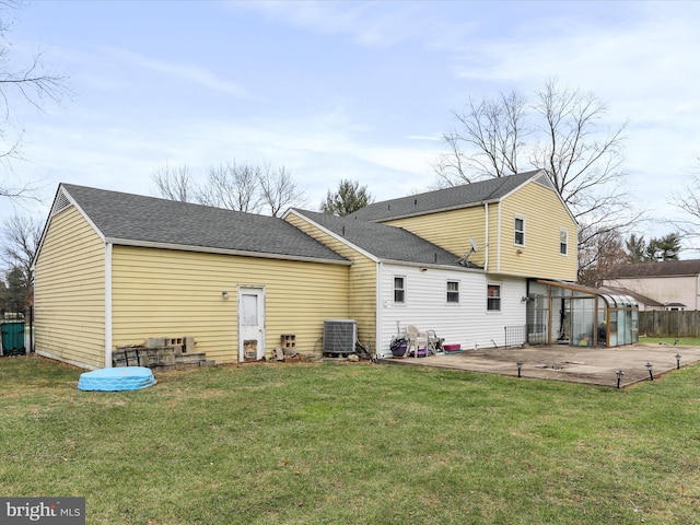 rear view of house featuring a lawn, cooling unit, and a patio