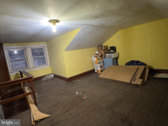 additional living space with dark wood-type flooring and vaulted ceiling