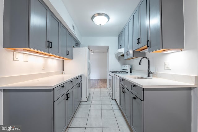 kitchen featuring gray cabinets, white appliances, sink, and light tile patterned floors