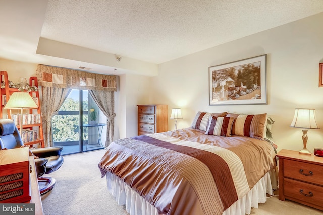 carpeted bedroom with access to exterior and a textured ceiling