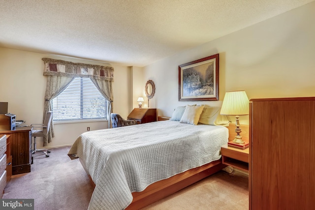 bedroom featuring light colored carpet and a textured ceiling