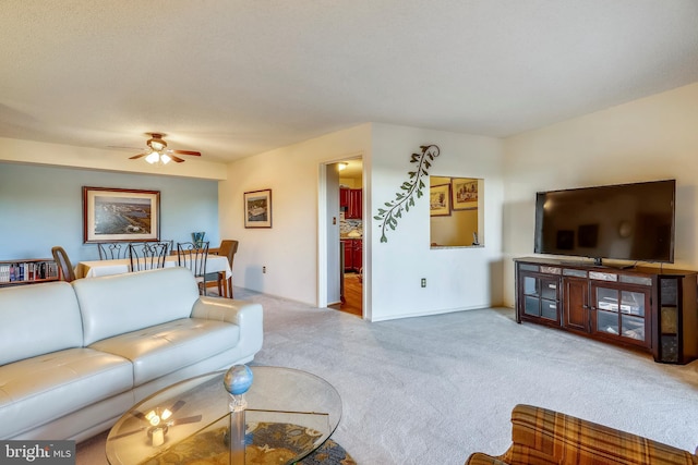 carpeted living room with ceiling fan