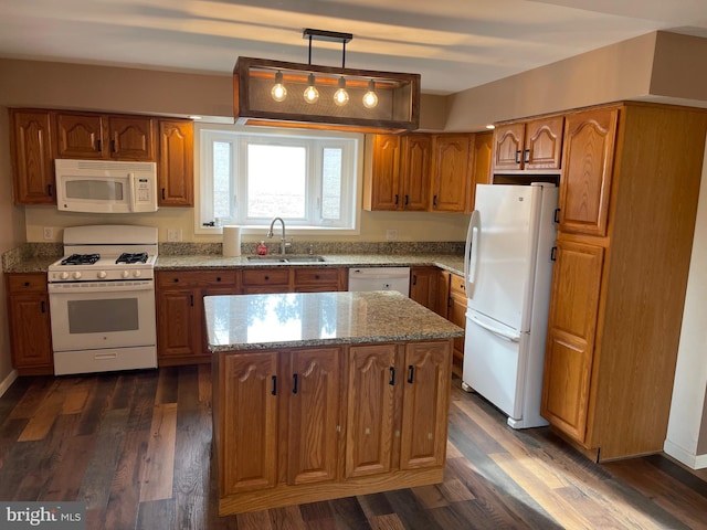 kitchen with dark hardwood / wood-style flooring, decorative light fixtures, a kitchen island, sink, and white appliances