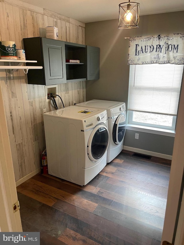 laundry room featuring cabinets, washer and clothes dryer, and dark wood-type flooring