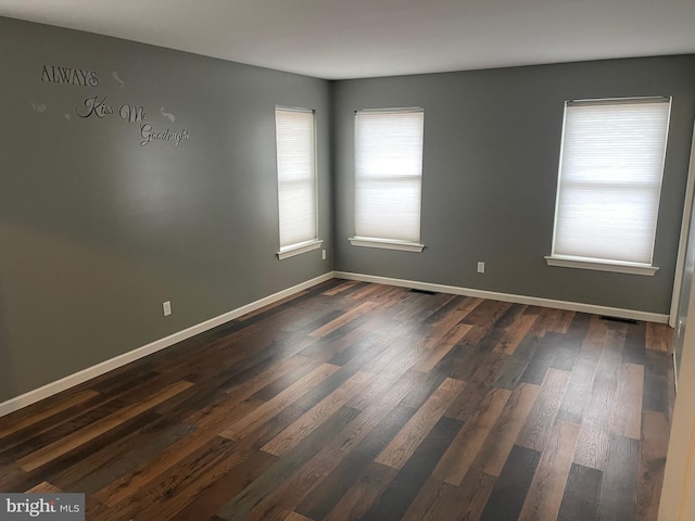 unfurnished room with dark hardwood / wood-style flooring