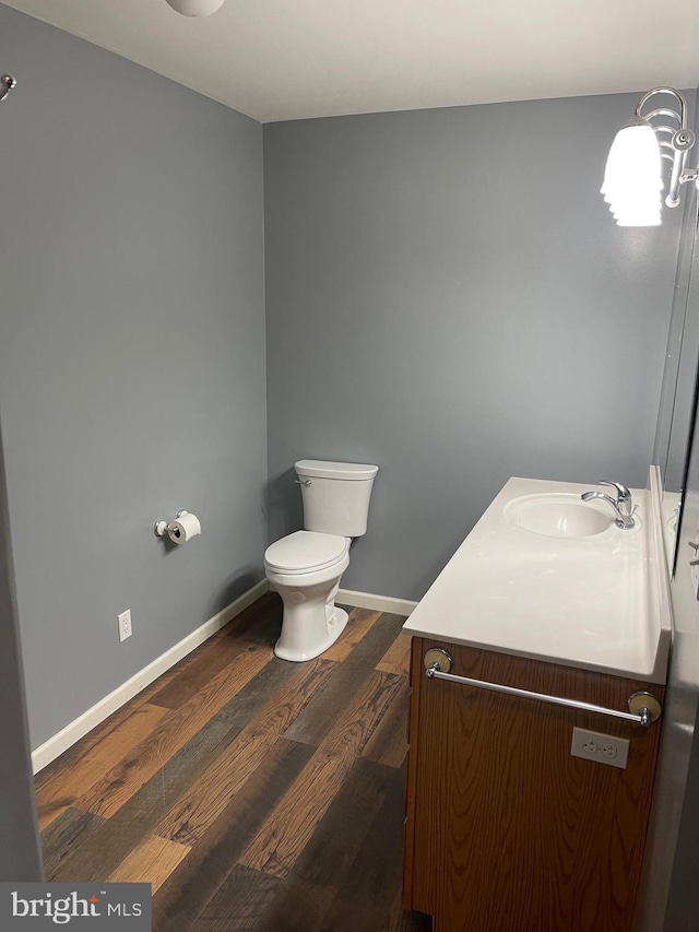 bathroom with hardwood / wood-style flooring, vanity, and toilet