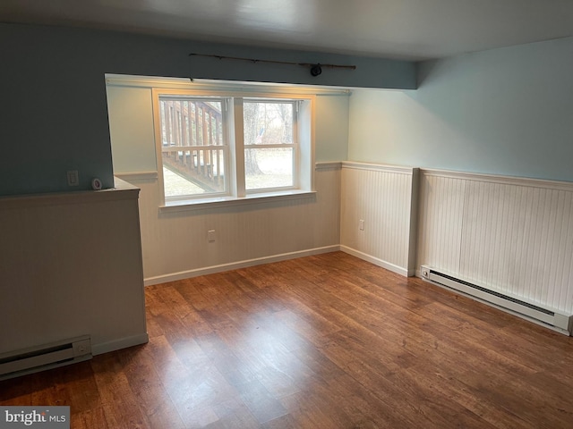 spare room with hardwood / wood-style floors and baseboard heating