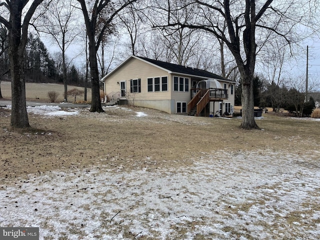 view of snow covered exterior with a sunroom and a wooden deck