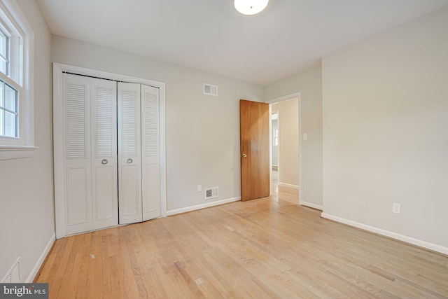 unfurnished bedroom with a closet and light hardwood / wood-style floors