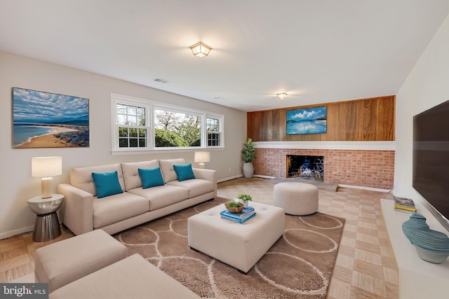 living room featuring a fireplace and brick wall