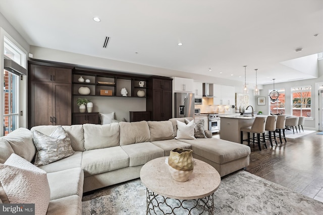 living room featuring hardwood / wood-style flooring and sink