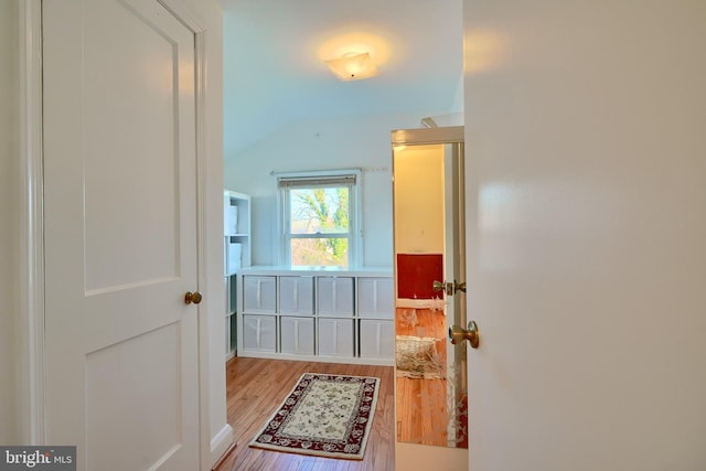 doorway featuring light hardwood / wood-style floors and vaulted ceiling