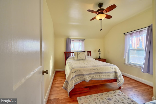 bedroom with ceiling fan, vaulted ceiling, light hardwood / wood-style flooring, and multiple windows