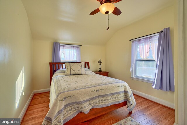 bedroom with light hardwood / wood-style floors, ceiling fan, and lofted ceiling