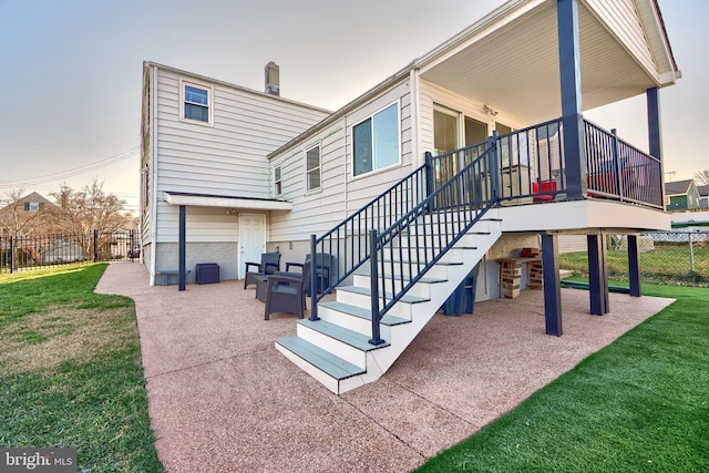 rear view of house featuring a patio and a lawn