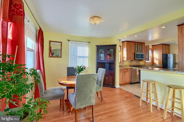 dining room featuring light wood-type flooring and a wealth of natural light