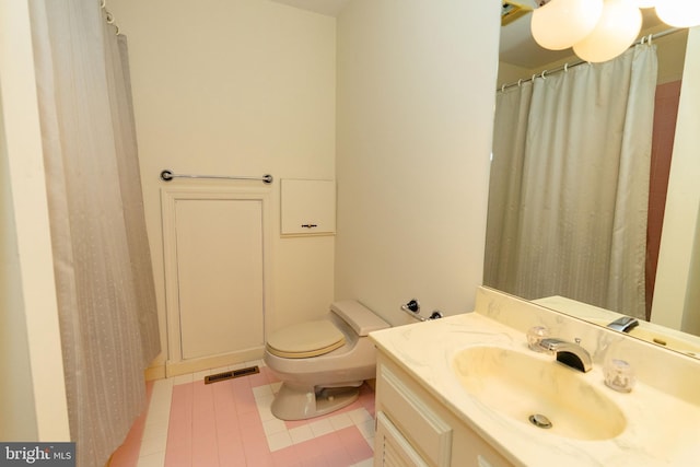 bathroom featuring tile patterned flooring, vanity, and toilet