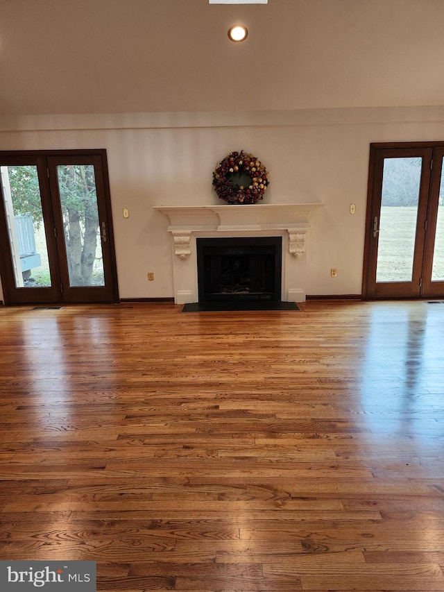 unfurnished living room with hardwood / wood-style flooring and a wealth of natural light