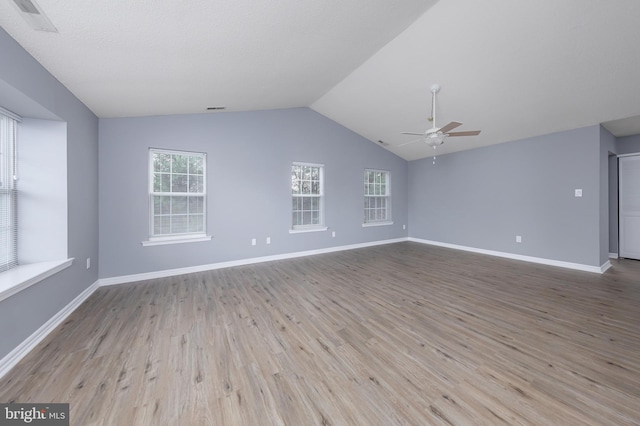 unfurnished room with light hardwood / wood-style floors, vaulted ceiling, and ceiling fan