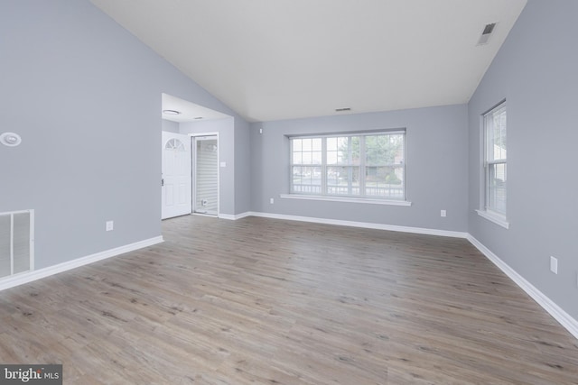 empty room featuring lofted ceiling and light hardwood / wood-style flooring