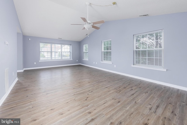 spare room featuring ceiling fan, light hardwood / wood-style floors, a wealth of natural light, and vaulted ceiling