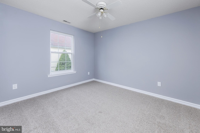 carpeted empty room with ceiling fan and a textured ceiling