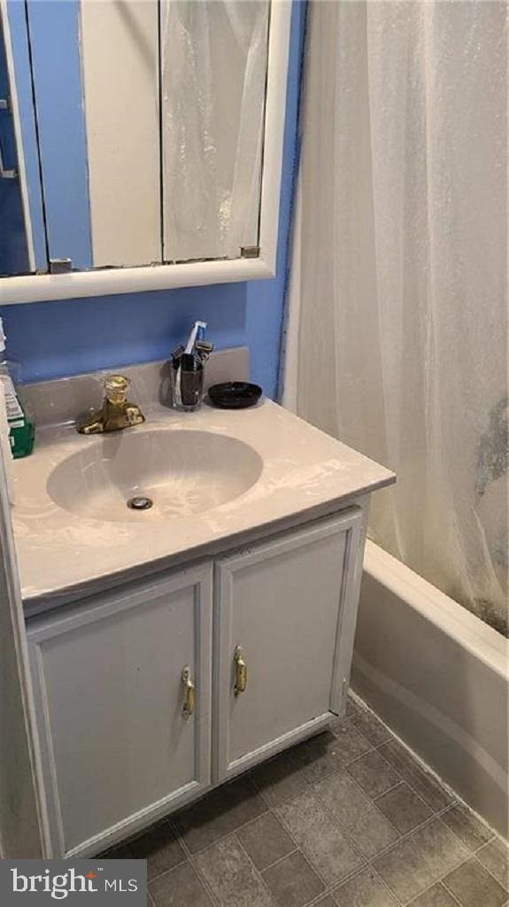 bathroom featuring tile patterned flooring, vanity, and  shower combination