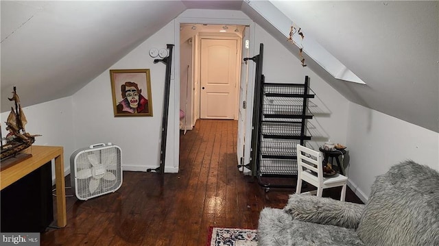 additional living space featuring dark wood-type flooring and vaulted ceiling