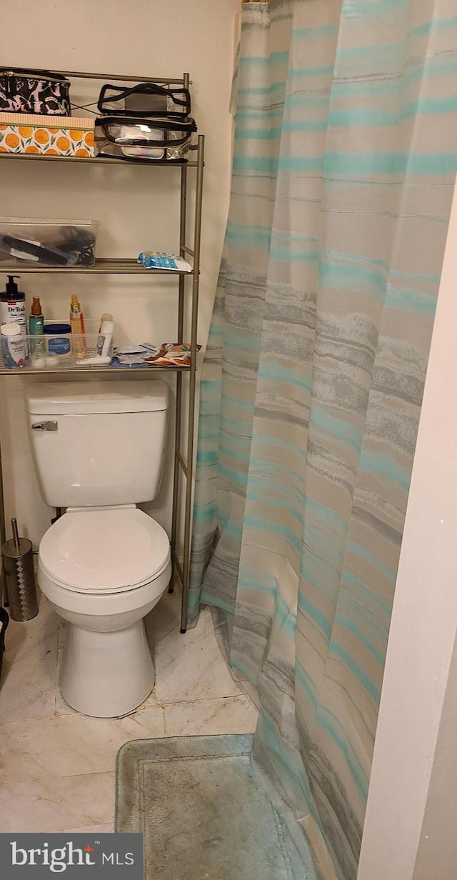 bathroom featuring walk in shower and toilet