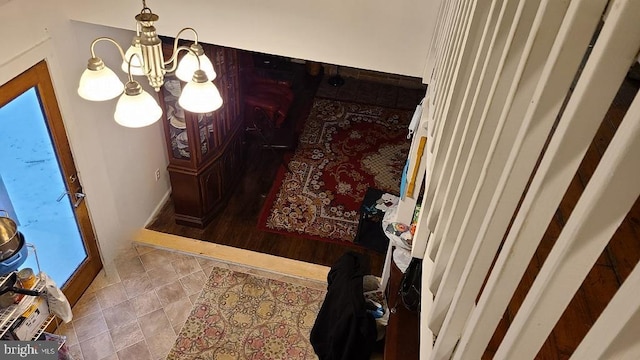 tiled entryway with a chandelier