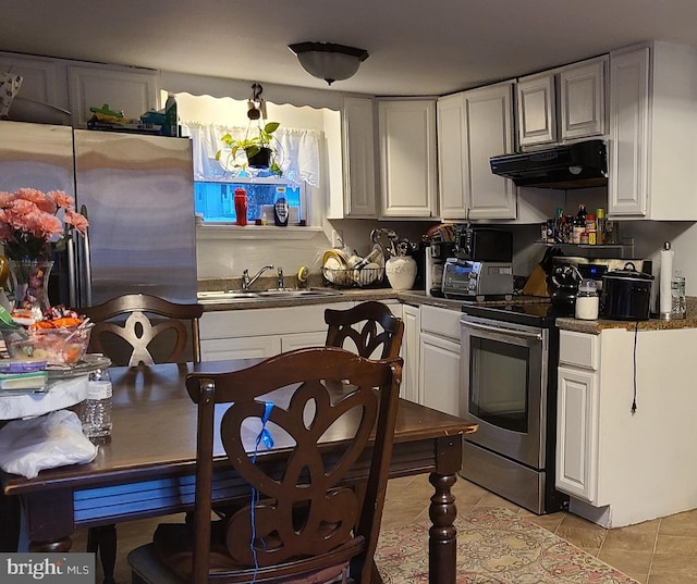 kitchen featuring white cabinets, appliances with stainless steel finishes, light tile patterned flooring, and sink