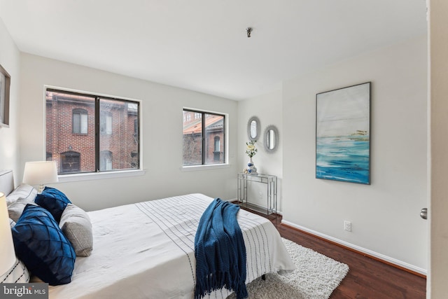 bedroom with baseboards and wood finished floors