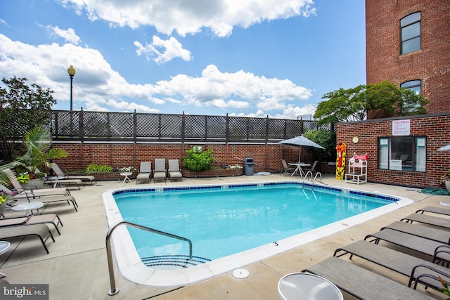 pool with a patio and fence