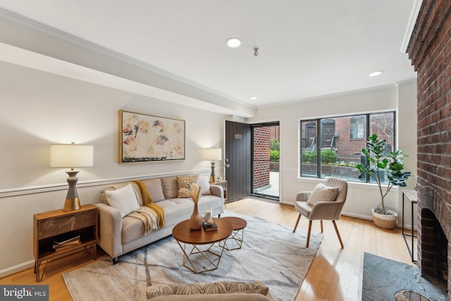 living area with crown molding, baseboards, recessed lighting, a fireplace, and wood-type flooring