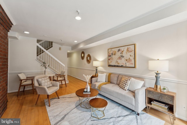 living area with recessed lighting, stairway, wood finished floors, and ornamental molding