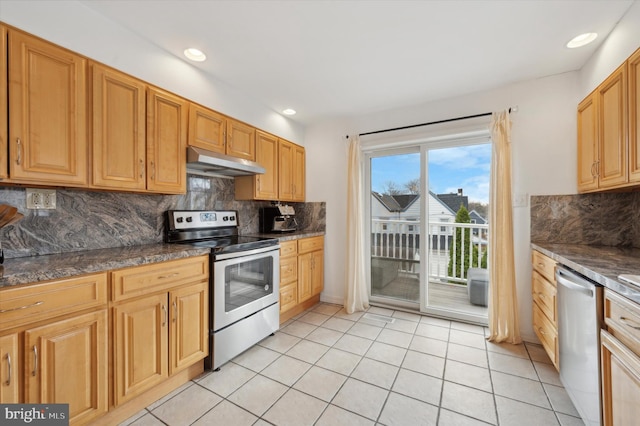 kitchen with decorative backsplash, light tile patterned floors, appliances with stainless steel finishes, and dark stone counters