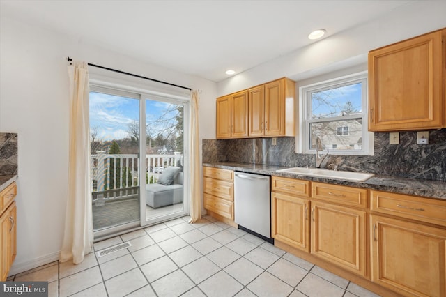 kitchen featuring decorative backsplash, sink, light tile patterned floors, and stainless steel dishwasher